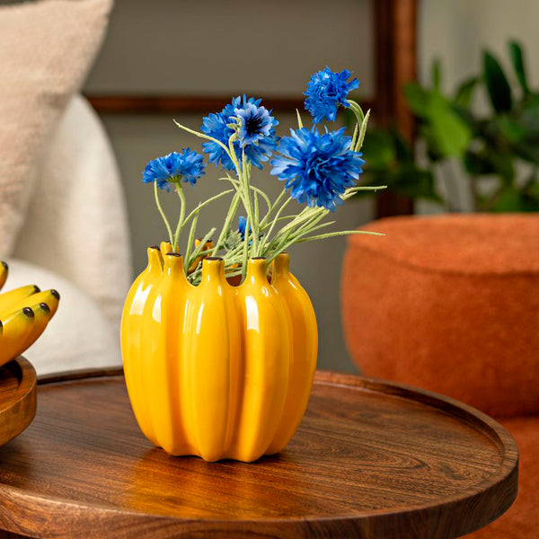 jarrón de cerámica en forma de plátanos sobre mesa de madera