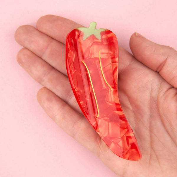 Pinza de pelo en forma de chile rojo sobre palma de la mano – Coucou Suzette