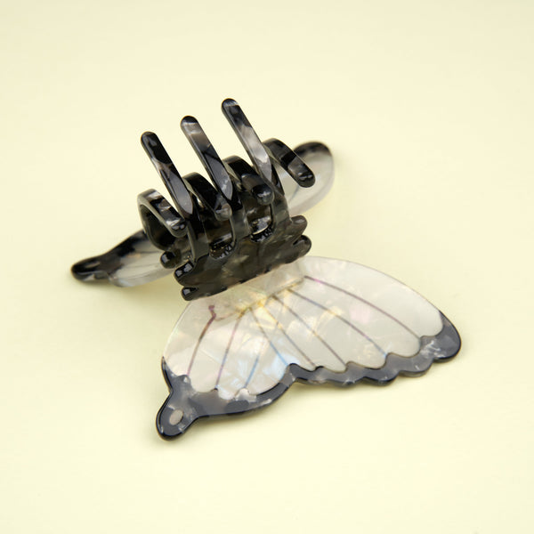 Detalle de la parte trasera de la pinza mariposa blanca - mecanismo dorado