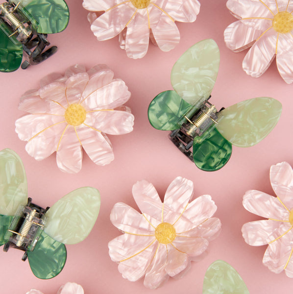 Pinzas para el pelo Coucou Suzette modelo mariposa verde y flor rosa en disposición decorativa