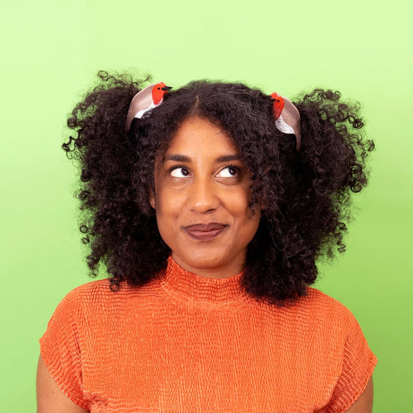 Modelo usando dos pinzas petirrojo en el cabello