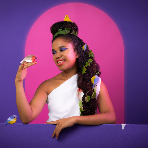 Modelo creativa sujetando pinza petirrojo como parte de look escénico