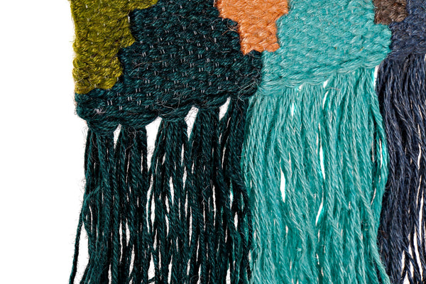 Flecos de hilo en tonos verde esmeralda, turquesa y crudo del tapiz decorativo – Brocantia