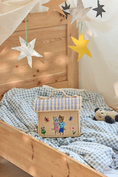 bolsa decorativa de rafia sobre cama infantil con ilustraciones de Nathalie Lété Brocantia