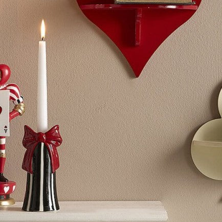 candelabro con vela blanca sobre mueble de decoración navideña