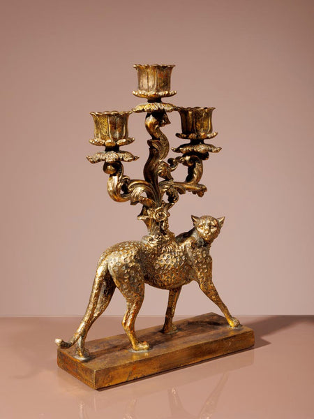 Candelabro dorado vintage con forma de felino visto en perspectiva lateral decorativa