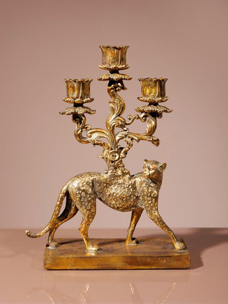 Figura decorativa de felino con candelabro de tres brazos para velas sobre base rectangular