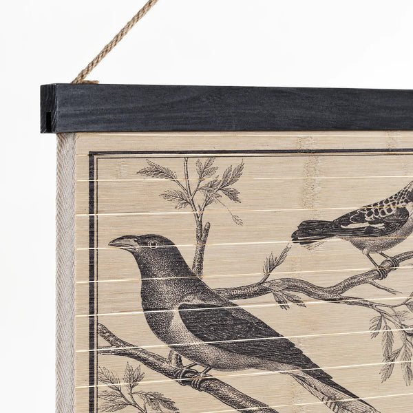 Detalle del cartel de madera con pájaros, listón negro superior y cuerda natural