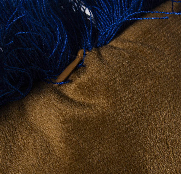 Detalle de terciopelo dorado y flecos azul intenso