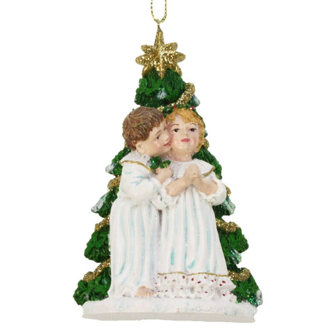 colgante navideño con niñas frente al árbol de Navidad