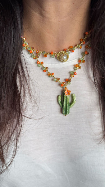 Collar artesanal de cerámica con cactus decorativo y tejido crochet italiano sobre modelo.