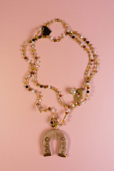 Collar de cuentas doradas y símbolo de buena suerte