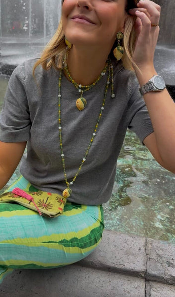 Mujer con collar y pendientes de limón siciliano pintados a mano, artesanía de Palermo