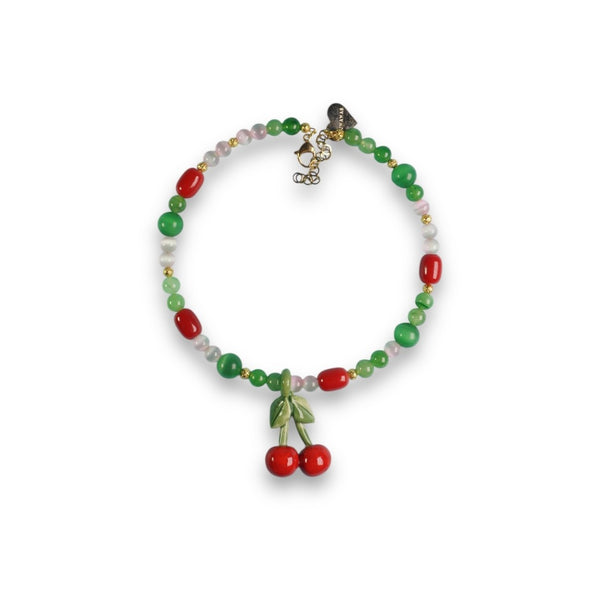 Detalle de cerezas de cerámica hechas a mano en collar