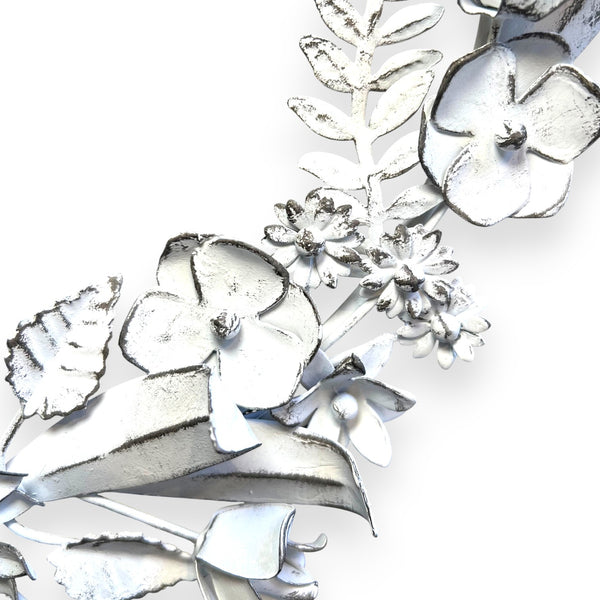 detalle de flores en corona de metal artesanal blanca