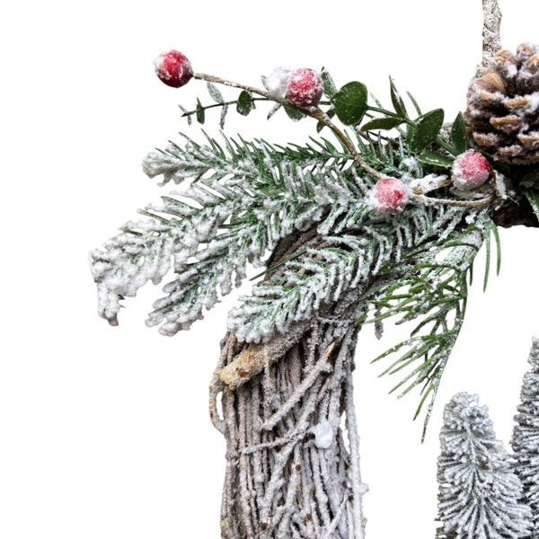 detalles de ramas nevadas y piñas en corona de Navidad