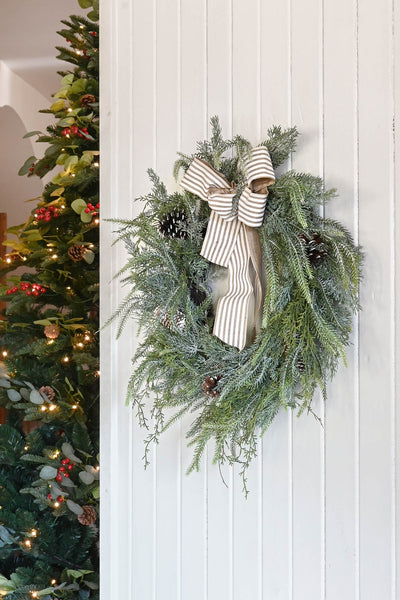 adorno navideño natural con piñas y lazo decorativo