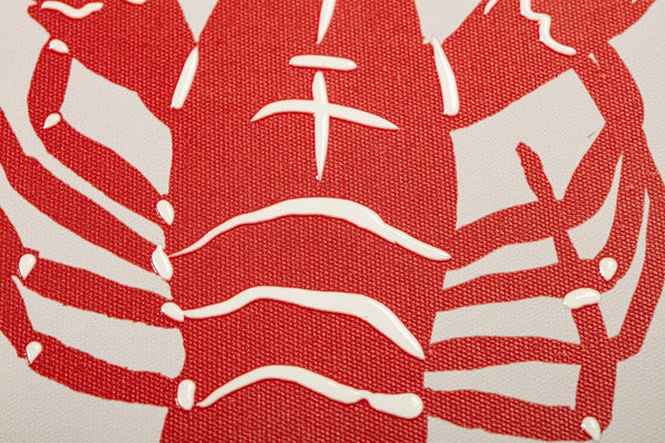 Detalle de ilustración de langosta roja en relieve sobre lienzo decorativo de inspiración marina.