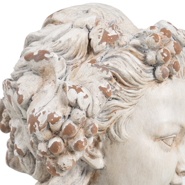 Detalle de la textura de uvas y hojas en busto decorativo clásico.