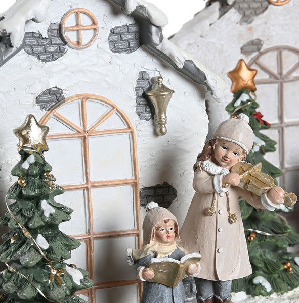 Adorno navideño con niñas cantando villancicos