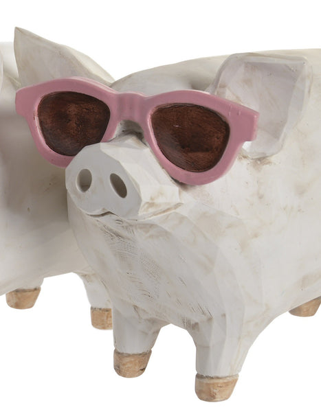 Detalle de figura de cerdo de resina con gafas de sol rosas.