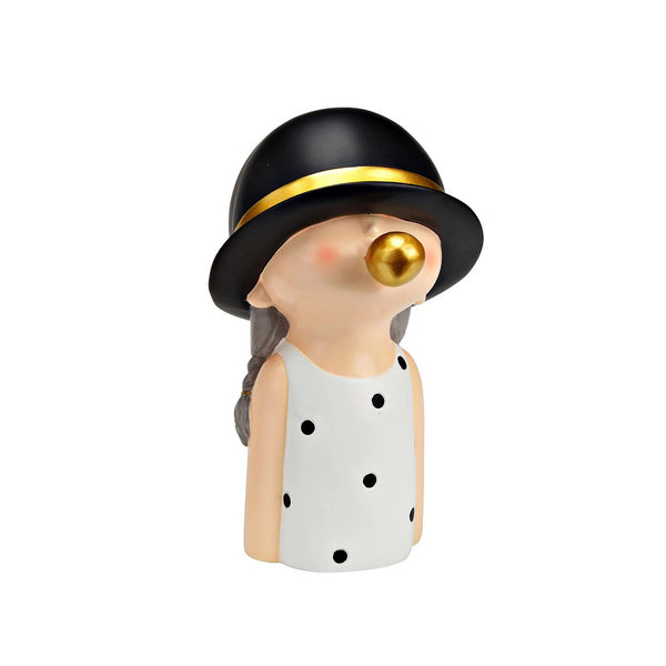 Figura niña chicle de resina con vestido blanco de lunares, sombrero negro y burbuja dorada.