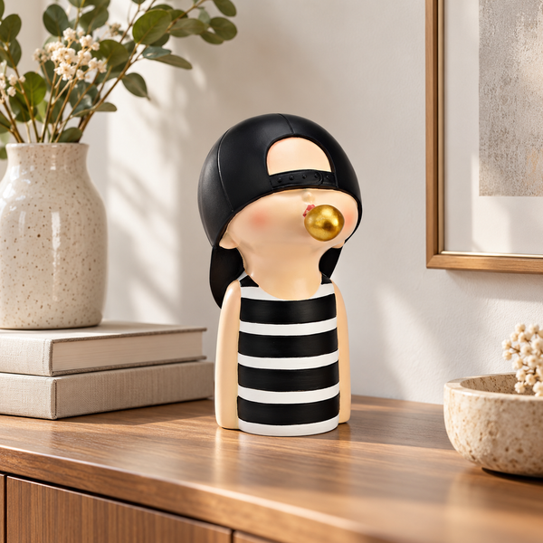 Figura niño con chicle dorado sobre aparador de madera en ambiente contemporáneo.