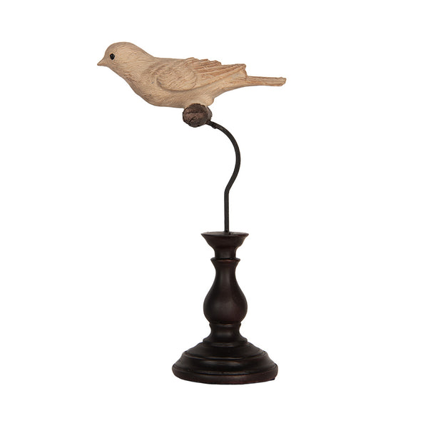 Figura decorativa de pájaro crema sobre pedestal oscuro