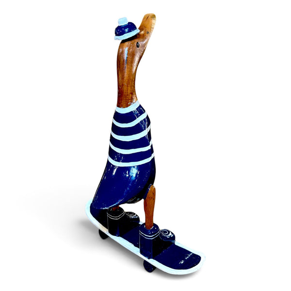 Figura artesanal de pato con camiseta azul y monopatín vista en perspectiva