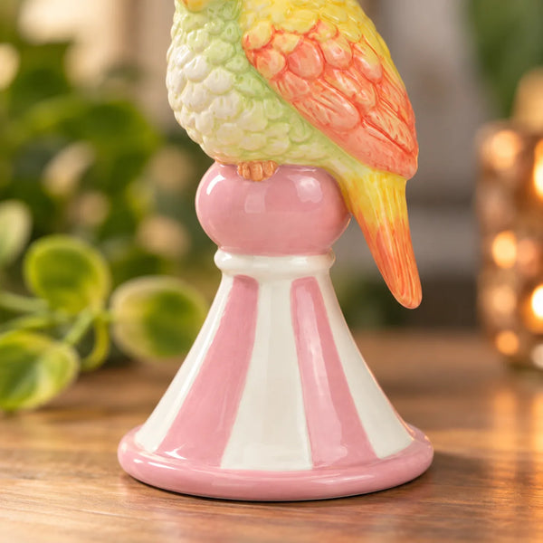 Detalle del pedestal rosa y blanco de la Figurita Loro Amarillo de cerámica.
