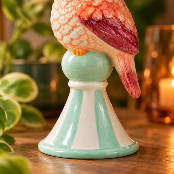 Detalle de la base verde menta y blanca de la Figurita Loro Rosa de cerámica.