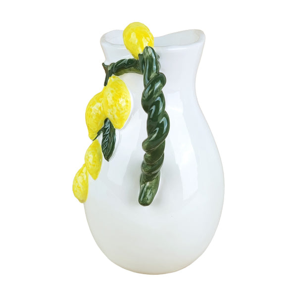 Parte trasera de jarra de porcelana blanca con asa en forma de rama y limones en relieve.