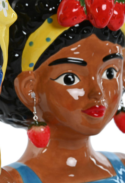 "Primer plano de jarrón decorativo en forma de cabeza de mujer negra con pendientes de fresa, pañuelo amarillo con lunares y frutas en el cabello – Brocantia tienda de decoración Oviedo"