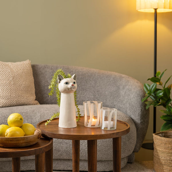 Jarrón con diseño de gato usado como florero decorativo en mesa auxiliar de salón moderno