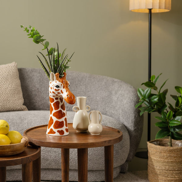 Jarrón con diseño de jirafa usado como florero decorativo en salón con estilo natural y moderno