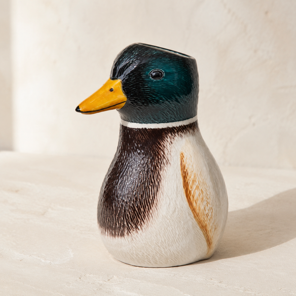 Primer plano del jarrón decorativo con forma de pato en tonos verde, marrón y blanco