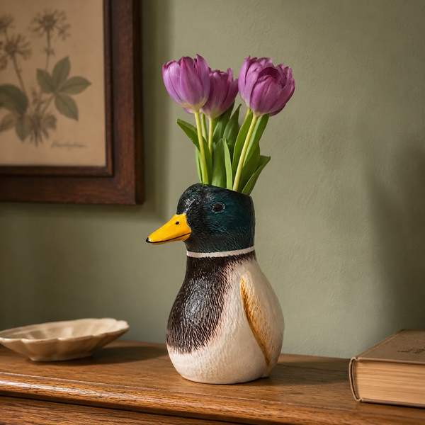 Jarrón pato con tulipanes morados decorando una cómoda de madera