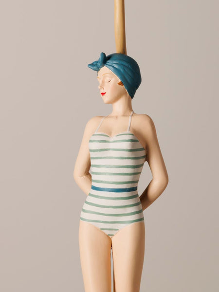 Detalle lámpara vintage con traje de baño rayas y turbante azul