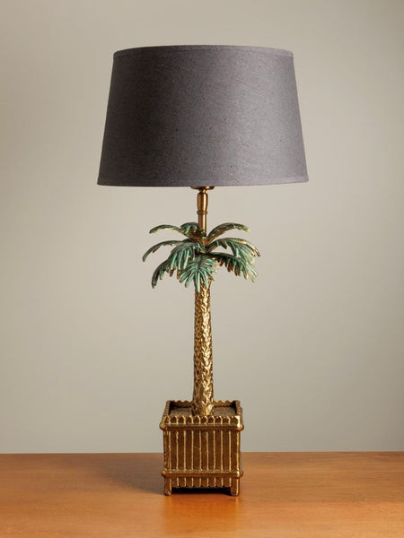 lámpara exótica de metal dorado y hojas verdes