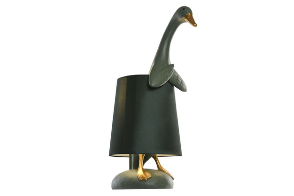 Lámpara decorativa en forma de pato con pantalla verde oscuro y figura asomando con estilo juguetón