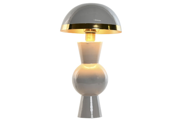 Lámpara de sobremesa seta gris encendida con luz cálida y base geométrica de metal.