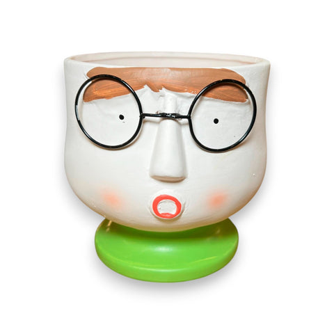 macetero de cerámica con cara y gafas redondas sobre base verde – diseño decorativo original Brocantia tienda de decoración