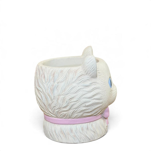 Vista lateral del mini macetero gato crema con relieve de pelo, ojos azules y lazo rosa.