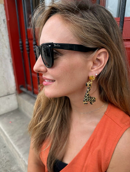 Mujer con pendientes de jirafa artesanales estilo boho chic