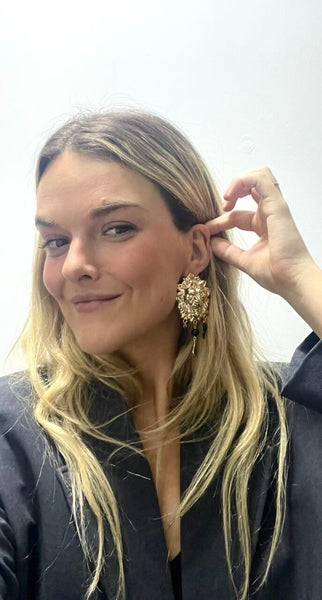 Mujer luciendo pendientes con símbolo de protección