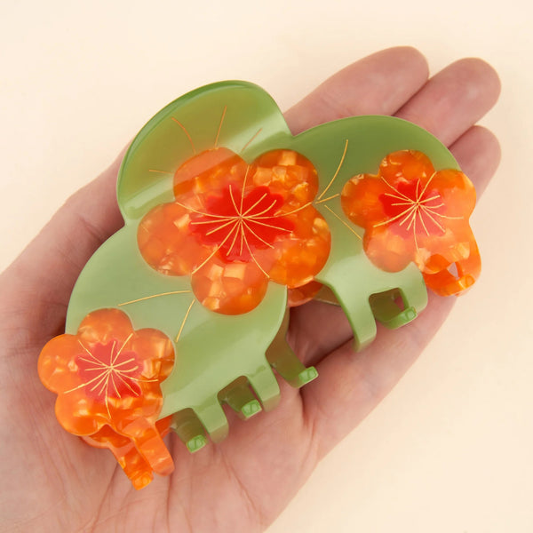 Pinza de pelo decorativa verde y naranja en uso