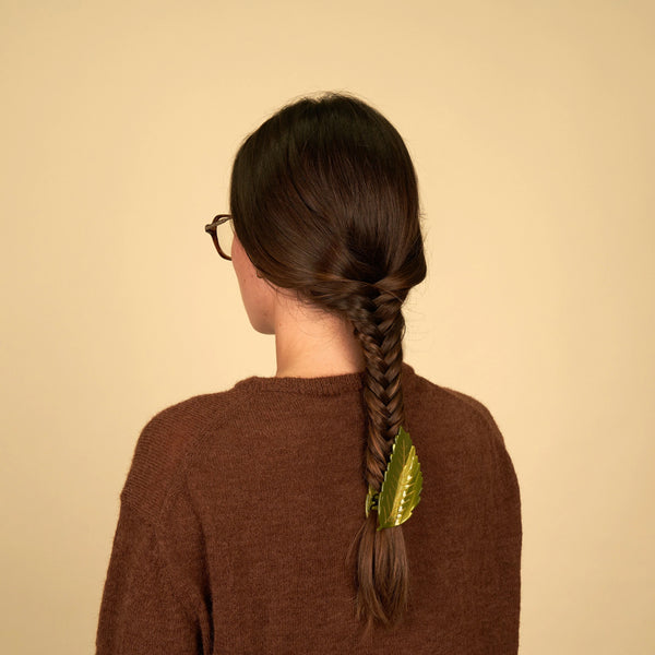 Mujer con trenza decorada con pinza de hoja de castaño