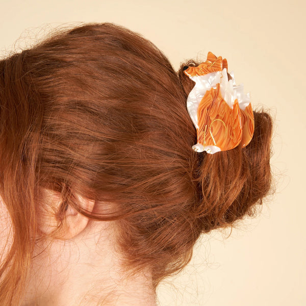 Pinza de pelo con forma de zorro Coucou Suzette colocada en un moño sobre cabello pelirrojo.