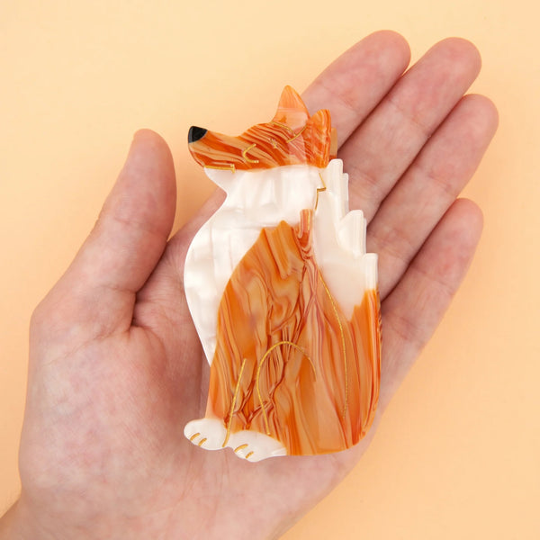 Pinza de pelo Zorro Coucou Suzette en acetato naranja y blanco mostrada sobre una mano para apreciar su tamaño.