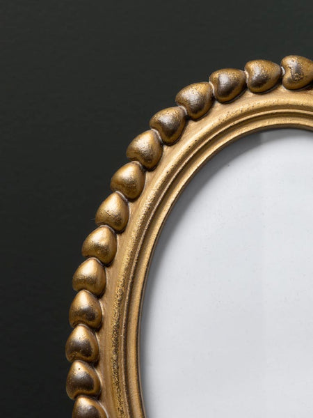 Detalle de marco dorado con relieve de corazones